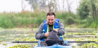 Mężczyzna płynie kajakiem wśród zieleni podczas spokojnej wyprawy