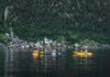 Trzech kajakarzy na jeziorze Hallstatt z widokiem malowniczej wioski
