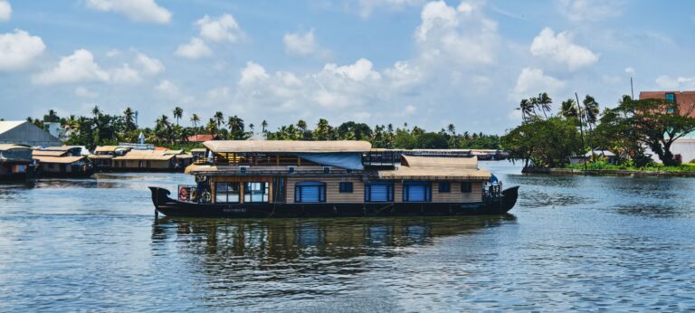 Tradycyjny houseboat płynący po rozlewiskach Kerali pod błękitnym niebem